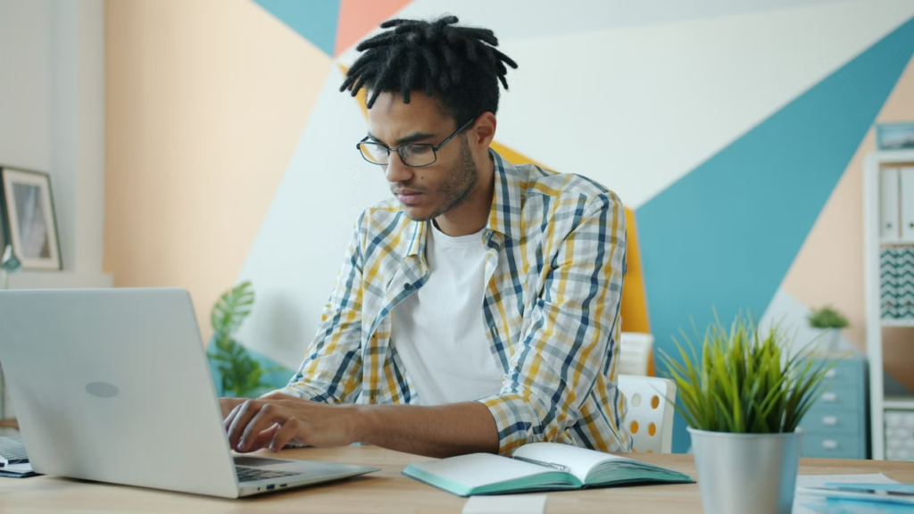 Freelancer working on a laptop at a desk in a bright home office